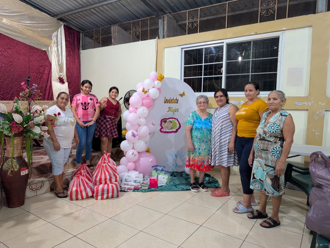 Women gathered at a Levántate Mujer event with gifts and aid